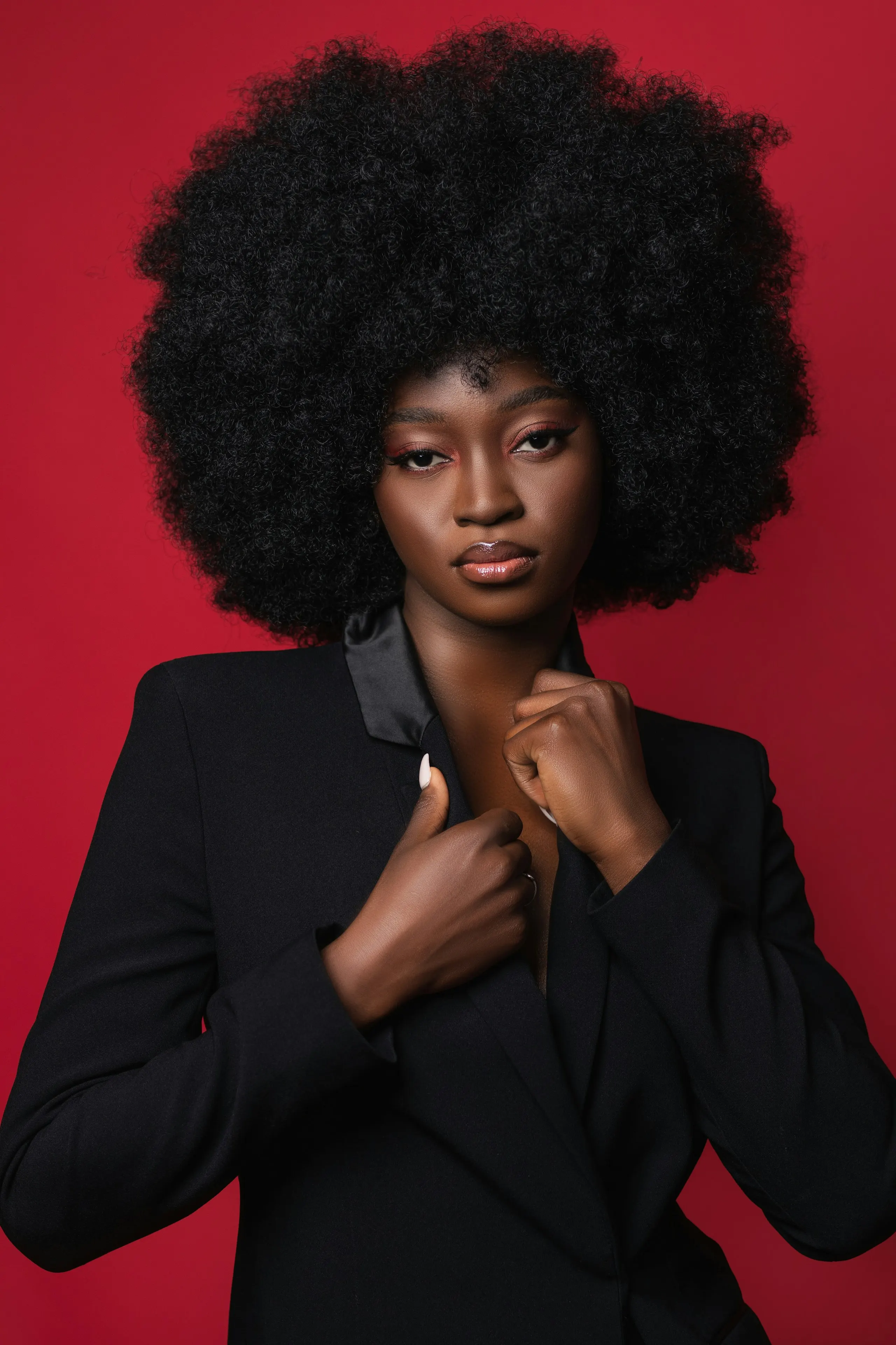 A studio portrait against a red backdrop