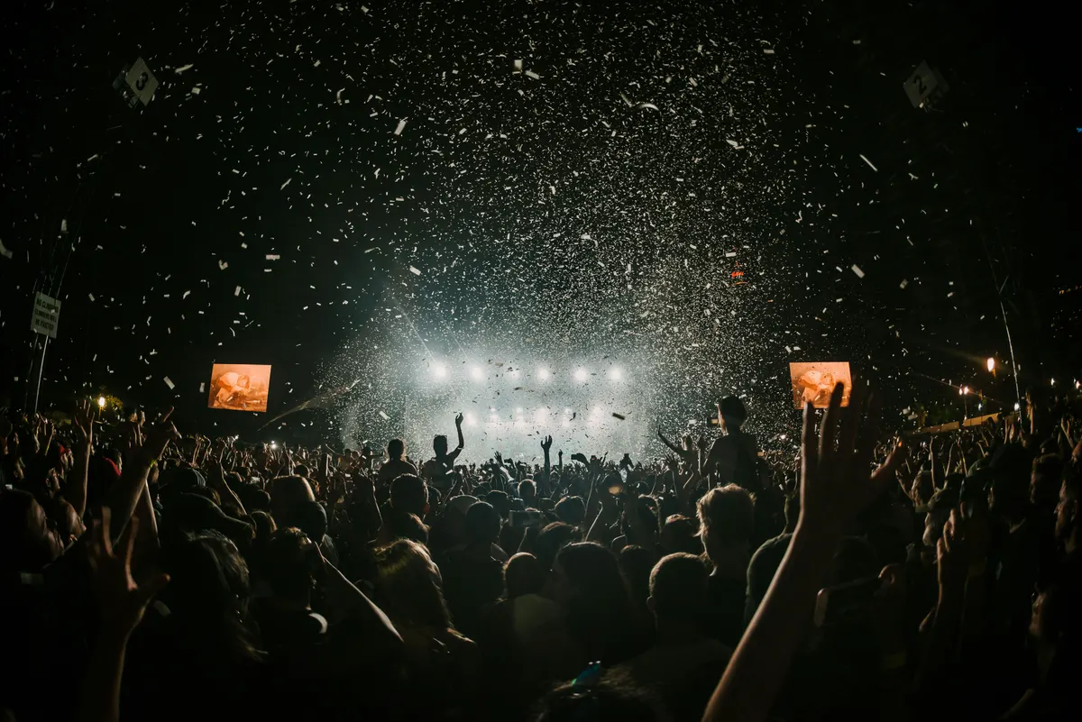 A crowd in front of a lit stage