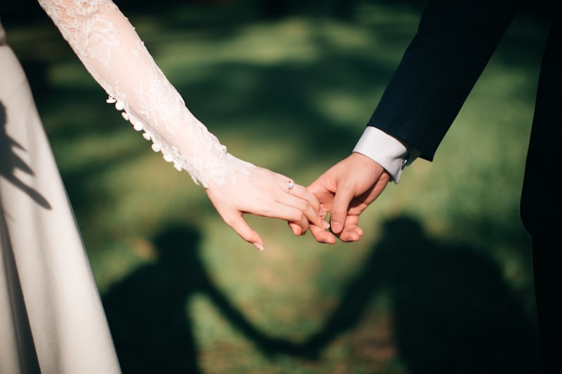 Couple holding hands, wedding ring detail